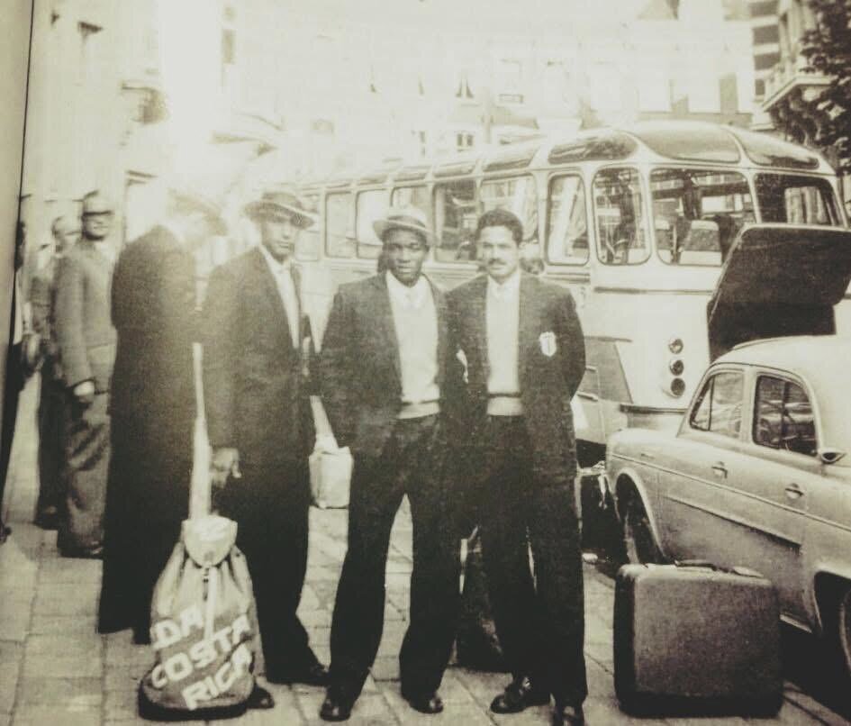 Men in suits standing near a car.